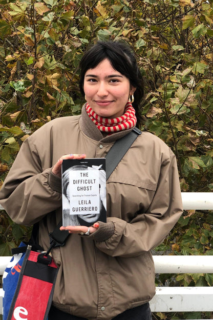 Person holding a product package outdoors with trees in the background