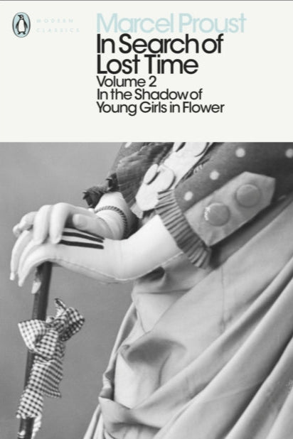 Book cover of 'In Search of Lost Time' by Marcel Proust with a statue and young girl in flower attire.